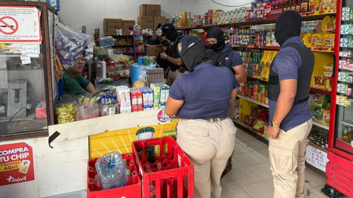 Inspectores durante la verificación de mercancía sin documentación en un minisúper.