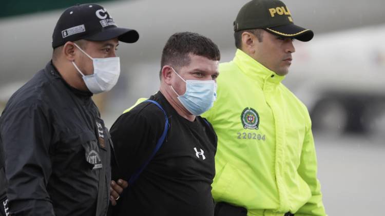 Fotografía de archivo del 8 de junio de 2022 de Francisco Luis Correa Galeano (c) siendo trasladado por un agente de la Policía y del Cuerpo Técnico de Investigación (CTI) en el Comando Aéreo de Transporte Militar (CATAM) hacia el Búnker de la Fiscalía General de la Nación, en Bogotá (Colombia). EFE/ Carlos Ortega