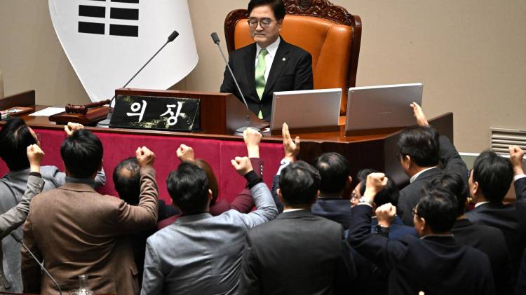 Los legisladores del gobernante Partido del Poder Popular de Corea del Sur (abajo) discuten con el presidente de la Asamblea Nacional, Woo Won-shik (arriba en el centro), durante la sesión plenaria para la votación de destitución del presidente interino Han Duck-soo en la Asamblea Nacional en Seúl el 27 de diciembre de 2024.