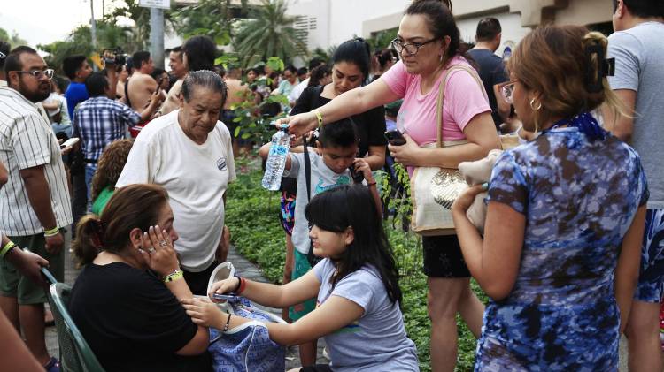 Personas atienden a una turista tras el sismo este viernes.