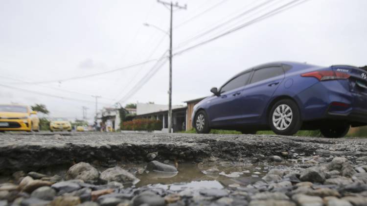 Fotografía del 11 de junio de 2025 de un vehículo pasando por una vía con huecos, en Ciudad de Panamá.