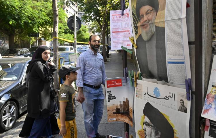 Una familia libanesa camina junto a los periódicos que informan sobre la muerte del líder de Hezbolá, Hassan Nasrallah, en la calle Hamra en Beirut, Líbano, el 29 de septiembre de 2024.