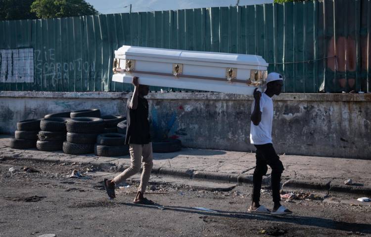 Fotografía de archivo de dos hombres que cargan un ataúd por una calle en Puerto Príncipe (Haití). EFE/ Johnson Sabin