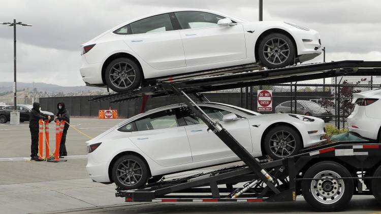 Fotografía de archivo de un camión transportador que lleva vehículos eléctricos mientras sale de la fábrica en Fremont, California, EE. UU., el 12 de mayo de 2020. EFE/EPA/John G. Mabanglo