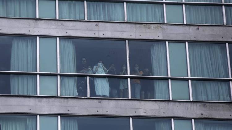Personas miran desde una ventana del hotel Decápolis este martes, en Ciudad de Panamá (Panamá).