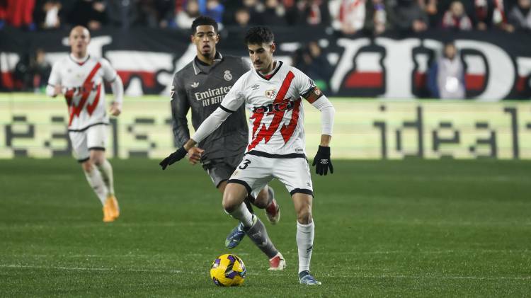 El centrocampista del Rayo Vallecano Óscar Valentín controla el balón ante Jude Bellingham.
