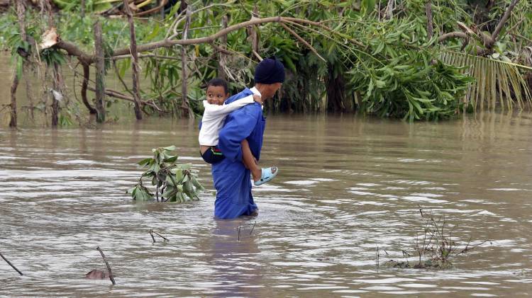 Niño en río crecido en Santiago de Cuba.