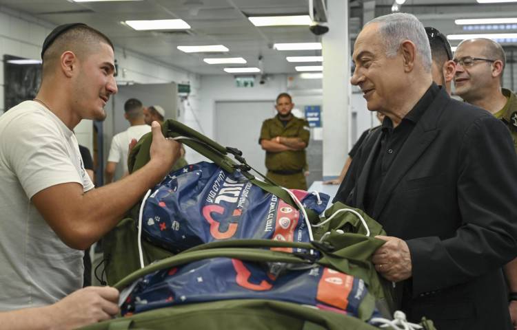 El primer ministro de Israel, Benjamín Netanyahu (2d), visita en la base de Tel Hashomer, cerca de Tel Aviv, a los reclutas del Cuerpo de Blindados y el de Ingeniería de Combate del ejército israelí. Netanyahu afirmó este miércoles que Israel está preparado tanto para la defensa como para el ataque ante la amenaza de un ataque desde varios frentes orquestado por Irán.