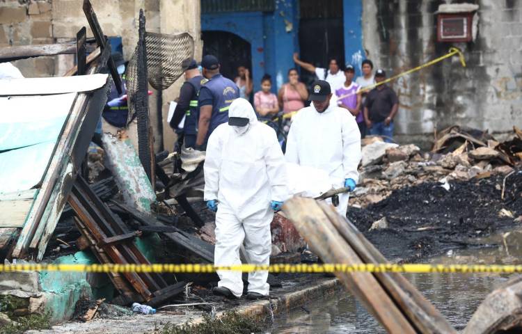 Momentos en que funcionarios del Ministerio Público retiran los cuerpos calcinados de las tres víctimas del incendio que redujo a cenizas el inmueble.