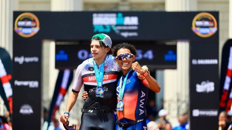 El panameño Eric Anel Acosta (d) celebra su llegada a meta tras una actuación que lo llevó al podio en dos categorías del Ironman 70.3 El Salvador.