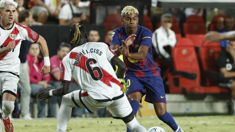 El centrocampista del Rayo Vallecano Pathé Ciss (i) lucha con Lamine Yamal, del FC Barcelona.