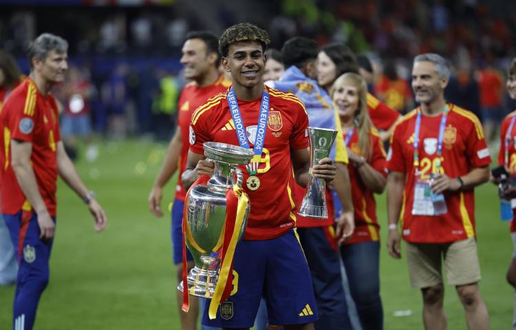 El jugador de la selección española Lamine Yamal, mejor jugador más joven del campeonato, con el trofeo durante la celebración de la victoria de la Eurocopa, tras vencer a Inglaterra en el partido de la final disputado en el Estadio Olímpico de Berlín.