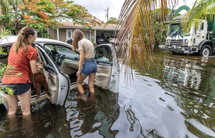 Dos personas junto a un automóvil en un vecindario inundado en Hallandale Beach, Florida, EE. UU., 13 de junio de 2024. EFE/EPA/Cristobal Herrera-Ulashkevich