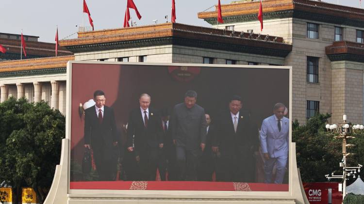 Una pantalla muestra al presidente chino, Xi Jinping (c); al presidente ruso, Vladimir Putin (3-i), y al líder norcoreano, Kim Jong Un (3-d), llegando a un desfile militar en Pekín, China.
