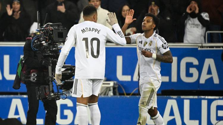 Rodrygo y Kylian Mbappé se saludan.
