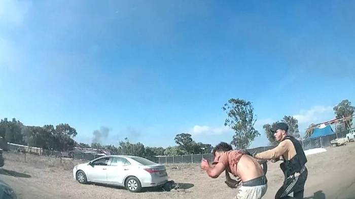 Miliciano se lleva a un joven en el festival de músicade Reim, que tuvo lugar el 7 de octubre de 2023.