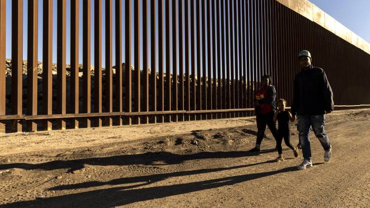 EA6070. BOGOTÁ (COLOMBIA), 12/12/2025.- Fotografía de archivo del 28 de octubre de 2022 de una familia caminando junto al muro fronterizo en Yuma, Arizona(Estados Unidos). Estados Unidos anunció este viernes la terminación de programas migratorios humanitarios de reunificación familiar para nacionales de Colombia, Cuba, Ecuador, El Salvador, Guatemala, Haití y Honduras, así como para sus familiares inmediatos, argumentando abusos de estas protecciones. EFE/EPA/ Etienne Laurent / ARCHIVO