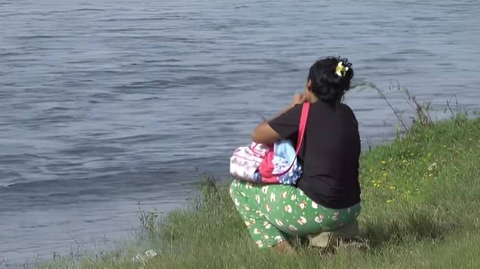 La madre de los menores llora desconsolada frente al río Changuinola mientras se realiza la búsqueda.