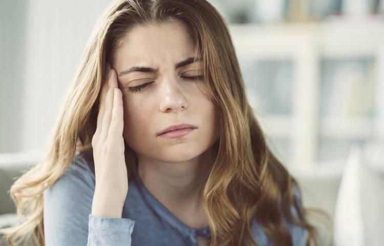 Young woman with headache in home interior