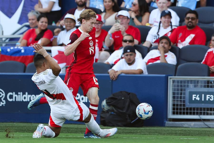 Anderson Santamaría (i), defensor de Perú, desafía al delantero de Canadá Jacob Shaffelburg (R) durante la Copa América.