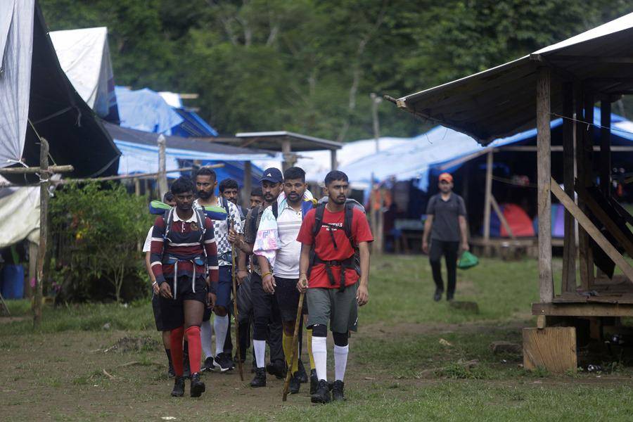 AME4730. DARIÉN (PANAMÁ), 31/08/2024.- Migrantes de diferentes nacionalidades cruzan un campamento en medio de un operativo este sábado, en plena selva del Darién, frontera natural entre Colombia y Panamá. Miembros del Servicio Nacional de Fronteras panameño dieron este sábado con un campamento en plena selva, en el que se vendían ilegalmente víveres y servicios a migrantes irregulares que cruzan esa peligrosa jungla en su viaje hacia Norteamérica. EFE/Carlos Lemos