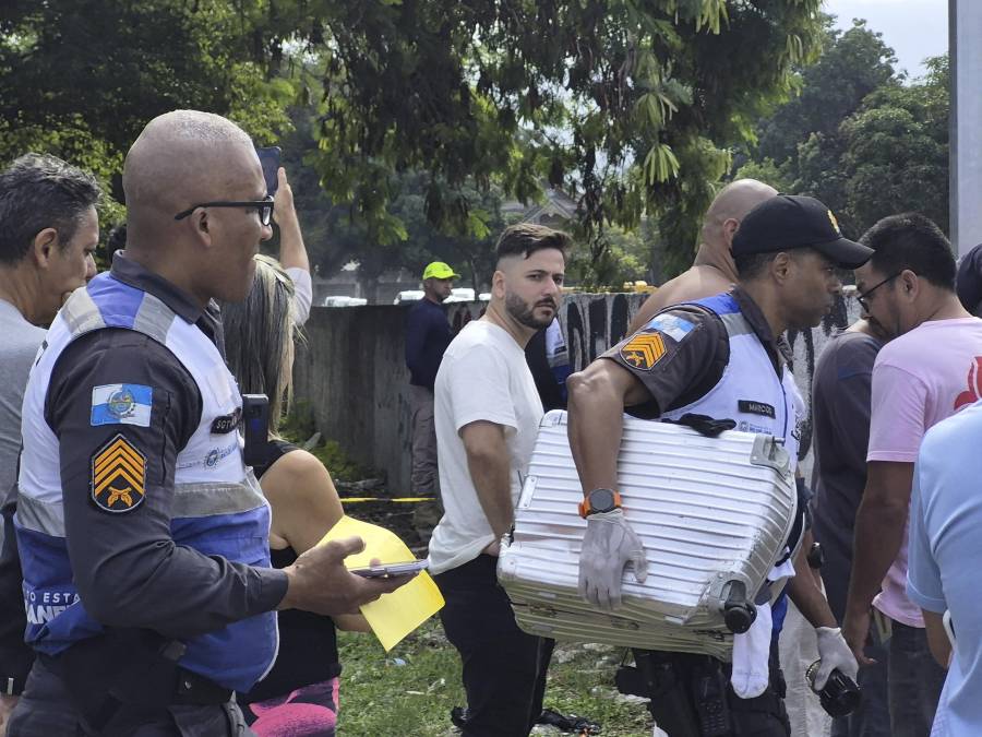 Un policía militar transporta una maleta recuperada en el lugar donde ocurrió el accidente de dos helicópteros en el barrio Recreio dos Bandeirantes, en Río de Janeiro (Brasil).